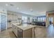 Open-concept kitchen featuring a large island, gray cabinets, and seamlessly flowing into the dining and living areas at 40848 W Hillman Dr, Maricopa, AZ 85138