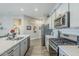 Modern kitchen features stainless appliances, light gray cabinets, granite counters and wood-look ceramic tile floors at 40848 W Hillman Dr, Maricopa, AZ 85138