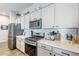 Stylish kitchen with white cabinets, stainless steel appliances, quartz countertops, and a gray subway tile backsplash at 40848 W Hillman Dr, Maricopa, AZ 85138