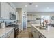 Modern kitchen with gray cabinets, quartz countertops, stainless steel appliances, and a stylish tile backsplash at 40848 W Hillman Dr, Maricopa, AZ 85138