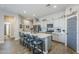 Bright kitchen boasts a large island with seating, stainless appliances, and wood-look tile flooring at 40848 W Hillman Dr, Maricopa, AZ 85138
