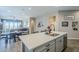 Spacious kitchen island with gray cabinets and stainless steel dishwasher that opens to the dining and living areas at 40848 W Hillman Dr, Maricopa, AZ 85138