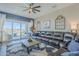 Cozy living room with a large sofa and sliding glass doors opening to a private backyard with a pool at 40848 W Hillman Dr, Maricopa, AZ 85138