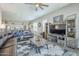 Open living room showcases a leather sectional, ceiling fan, neutral walls, and modern entertainment center at 40848 W Hillman Dr, Maricopa, AZ 85138