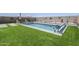 Backyard pool area with lounge chairs, artificial turf, and decorative features, creating a relaxing oasis at 40848 W Hillman Dr, Maricopa, AZ 85138