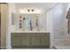 Bright bathroom featuring a double vanity, tile shower and stylish lighting fixtures at 4313 E Briarwood Ter, Phoenix, AZ 85048