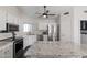 Spacious kitchen with white cabinets, stainless steel appliances, and an island with a granite countertop at 4313 E Briarwood Ter, Phoenix, AZ 85048