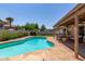 Inviting pool with flagstone surround, covered patio area and green lawn in backyard at 4313 E Briarwood Ter, Phoenix, AZ 85048