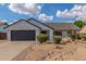 Charming single-story home with a black garage door, manicured lawn, and desert landscaping at 4340 E Nisbet Rd, Phoenix, AZ 85032