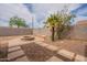 Desert landscaped backyard with stone pavers, and a built-in fire pit and seating at 4432 W Pleasant Ln, Laveen, AZ 85339