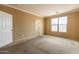 This bedroom boasts a large window, a door, neutral walls, and access to a closet at 4432 W Pleasant Ln, Laveen, AZ 85339