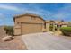 View of home's front exterior, driveway, tan paint, desert rock landscaping, and view of the roof and blue sky at 4432 W Pleasant Ln, Laveen, AZ 85339