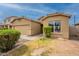 The home features a two-car garage, desert landscaping, and neutral-colored exterior paint at 4432 W Pleasant Ln, Laveen, AZ 85339