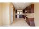 Bright kitchen featuring dark wood cabinets, stone countertops, with view into dining room at 4432 W Pleasant Ln, Laveen, AZ 85339