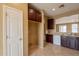 Bright kitchen with dark cabinets, a white door, and an open view to an adjacent room at 4432 W Pleasant Ln, Laveen, AZ 85339