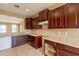 Features dark wood cabinets, stone countertops, tile backsplash, and an opening to the adjacent living area at 4432 W Pleasant Ln, Laveen, AZ 85339