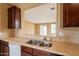 Features stone countertops, a stainless steel sink, and dark wood cabinets with an opening to the dining room at 4432 W Pleasant Ln, Laveen, AZ 85339