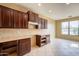 A spacious kitchen features dark wood cabinets and stone countertops adjacent to dining area with a large window at 4432 W Pleasant Ln, Laveen, AZ 85339