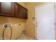 A laundry room with upper cabinets offers a functional space at 4432 W Pleasant Ln, Laveen, AZ 85339