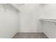 Walk-in closet featuring white shelving units and neutral carpeting at 4510 N 105Th Ave, Phoenix, AZ 85037