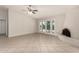 Bright living room featuring tiled floors, a ceiling fan, and french doors leading to a pool at 4510 N 105Th Ave, Phoenix, AZ 85037