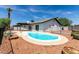 Backyard view featuring a kidney shaped pool with trees, bushes and palm trees at 4510 N 105Th Ave, Phoenix, AZ 85037
