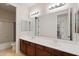 Bright bathroom featuring double sinks, wooden cabinetry, and a shower-tub combo at 4517 W Lodge Dr, Laveen, AZ 85339