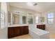 This luxurious bathroom boasts dual sinks, a soaking tub, and bright natural light at 4517 W Lodge Dr, Laveen, AZ 85339