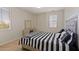 Cozy bedroom featuring a striped bedspread, vanity, and ample natural light from the window at 4517 W Lodge Dr, Laveen, AZ 85339