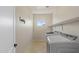 Functional laundry room with tile floors, open shelving, washer and dryer and a window at 4517 W Lodge Dr, Laveen, AZ 85339