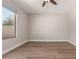 A spacious bedroom with light hardwood floors, base trim, neutral walls and a large window at 4639 E Cabrillo Dr, Gilbert, AZ 85297