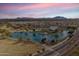 Stunning aerial view showcasing the community's lake, pool, clubhouse, and scenic mountain backdrop at 4772 E Portola Valley Dr # 102, Gilbert, AZ 85297