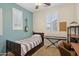 Bedroom featuring colorful accent wall, white shutters, ceiling fan, and neutral carpet at 4772 E Portola Valley Dr # 102, Gilbert, AZ 85297