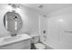 Bright bathroom featuring tiled shower-tub, a round mirror, and a vanity with solid surface countertop at 5504 N 69Th Ave, Glendale, AZ 85303
