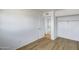 Bedroom with wood-look flooring, white walls, closet and an open doorway to the kitchen at 5504 N 69Th Ave, Glendale, AZ 85303