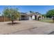 Attractive home with solar panels, a covered carport, and a blossoming front yard tree at 5504 N 69Th Ave, Glendale, AZ 85303