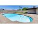 Refreshing in-ground swimming pool with a tanning shelf surrounded by well-kept backyard space at 5504 N 69Th Ave, Glendale, AZ 85303