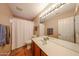 Bright bathroom featuring a large mirror, a toilet, and a shower curtain at 5521 W Northwood Dr, Glendale, AZ 85310