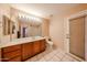 Bright bathroom with a large mirror, wood cabinet, and tiled floor; adjacent to the door at 5521 W Northwood Dr, Glendale, AZ 85310