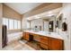 Large bathroom featuring a double sink vanity, a bath tub, and a window at 5521 W Northwood Dr, Glendale, AZ 85310