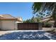 Spacious driveway leading to a well-maintained home with a modern garage and secure wooden gate at 5521 W Northwood Dr, Glendale, AZ 85310