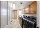 Modern laundry room with a pair of front-load washer and dryer and ample storage cabinets at 5521 W Northwood Dr, Glendale, AZ 85310