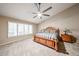 Bright main bedroom featuring a large window, ceiling fan, and carpet at 5521 W Northwood Dr, Glendale, AZ 85310