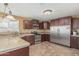 Kitchen features brown cabinets, stainless appliances, tile countertops, and tile floors at 7326 E Juanita Ave, Mesa, AZ 85209