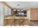 Eat-in kitchen features brown cabinets, stainless appliances, tile countertops, and a center island with bar seating at 7326 E Juanita Ave, Mesa, AZ 85209
