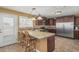 Eat-in kitchen features brown cabinets, stainless appliances, tile countertops, and a center island with bar seating at 7326 E Juanita Ave, Mesa, AZ 85209