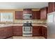 Kitchen features brown cabinets, stainless appliances, tile countertops, and tile floors at 7326 E Juanita Ave, Mesa, AZ 85209