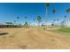 View of the putting green, palm trees, and clubhouse at 7326 E Juanita Ave, Mesa, AZ 85209