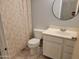 Cozy bathroom with a white vanity, a toilet, and a shower with patterned curtains at 7525 W Turney Ave, Phoenix, AZ 85033