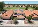 Aerial view of a home with solar panels, desert landscaping, and a community near a golf course at 7535 W Kimberly Way, Glendale, AZ 85308